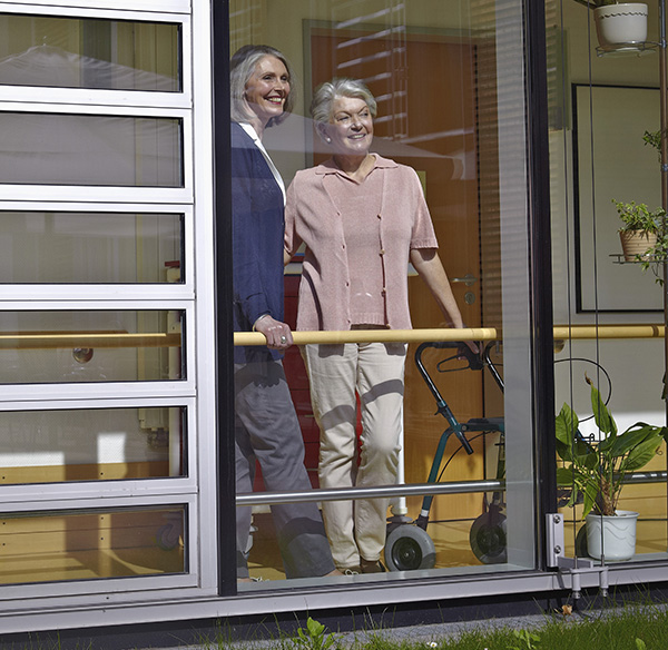 Elderly Woman Standing At Window