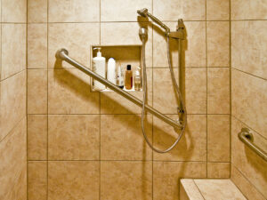 Shower remodeled to be handicap accessible with grab bars and shower seat. 
